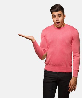 Genç komik adam tutan bir şey üzerinde palmiye el