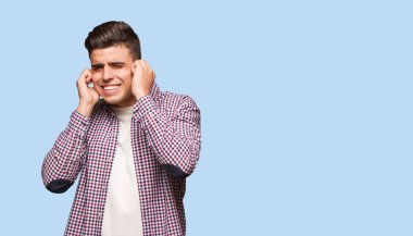 Elleriyle kulaklarını kapatan genç havalı adam.