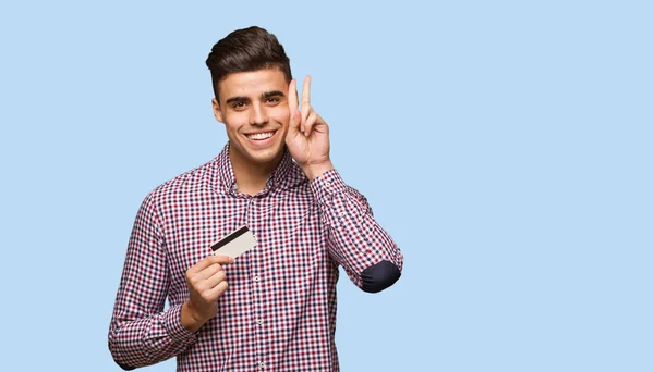 Jovem Segurando Cartão Crédito Divertido Feliz Fazendo Gesto Vitória — Fotografia de Stock