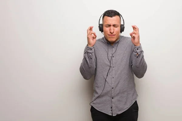 Ung Latin Man Lyssnar Musik Korsning Fingrar För Att Tur — Stockfoto