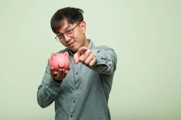 Jovem Asiático Homem Segurando Porquinho Banco Alegre Sorrindo Apontando Para — Fotografia de Stock