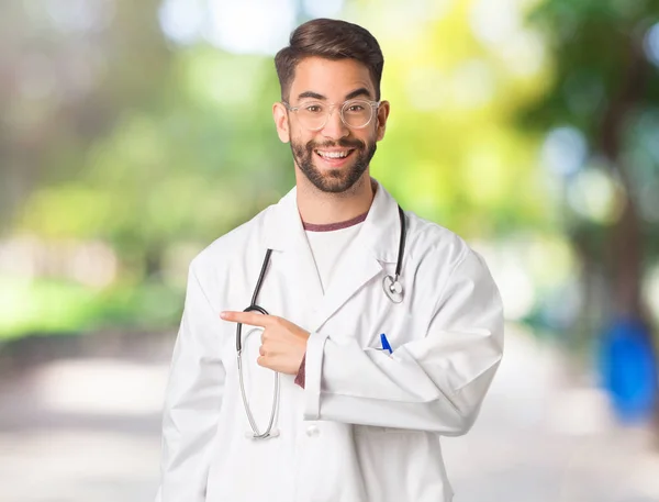 Jeune Homme Médecin Souriant Pointant Vers Côté — Photo