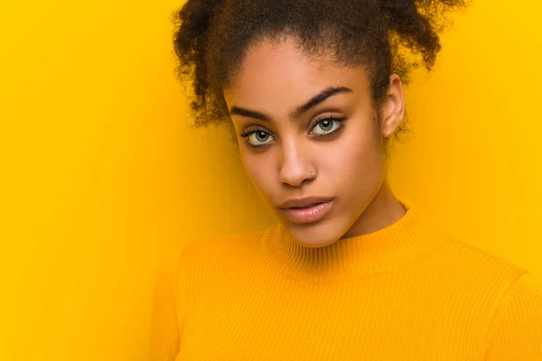 Jovem mulher negra closeup sobre uma parede laranja — Fotografia de Stock