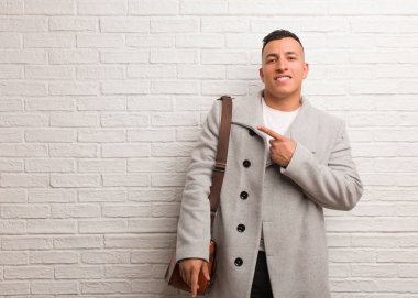 Genç Latin iş adamı gülümsüyor ve yüzünü gösteriyor.