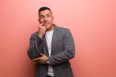 Genç, zarif Latin adam rahatlamış fotokopi odasına bakan bir şey düşünüyor.