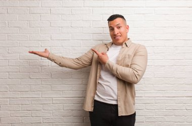 Genç Latin adam elinde bir şey tutuyor.