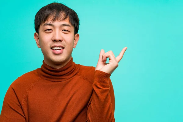 指で横を指す若い中国人男性 — ストック写真