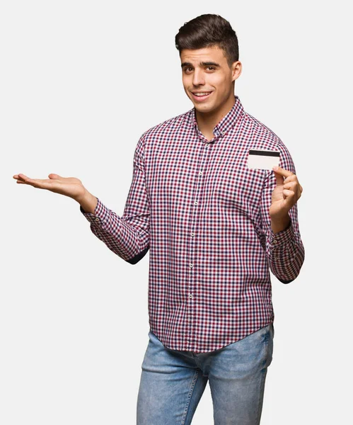 Junger Mann Mit Kreditkarte Verwirrt Und Zweifelhaft — Stockfoto