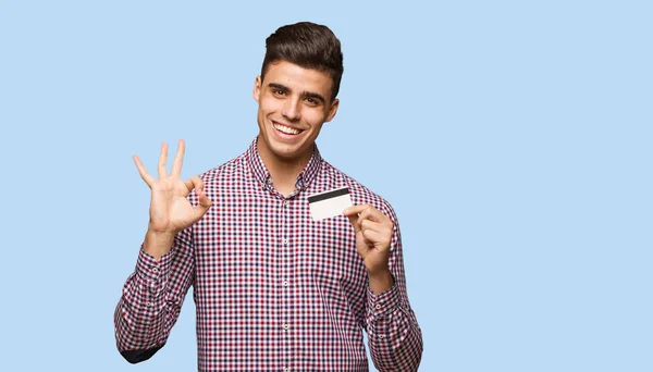 Jovem Segurando Cartão Crédito Alegre Confiante Fazendo Gesto — Fotografia de Stock