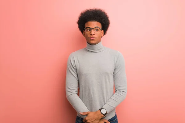 ピンクの壁の上の若いアフリカ系アメリカ人男性がアイデアを考える — ストック写真