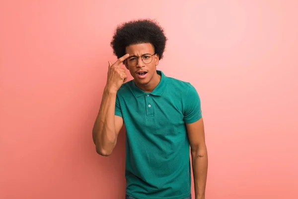 ピンクの壁の上に若いアフリカ系アメリカ人の男指で失望のジェスチャーを行う — ストック写真