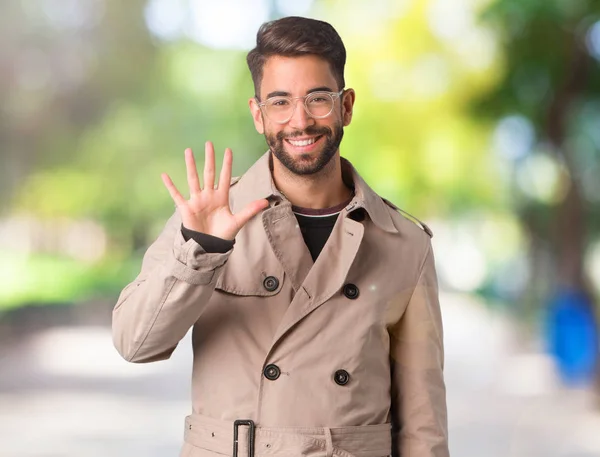 Joven Vistiendo Gabardina Mostrando Número Cinco — Foto de Stock