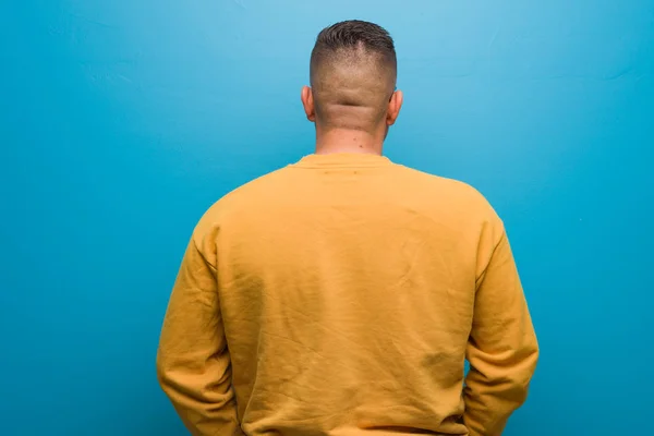 Young colombian man from behind, looking back