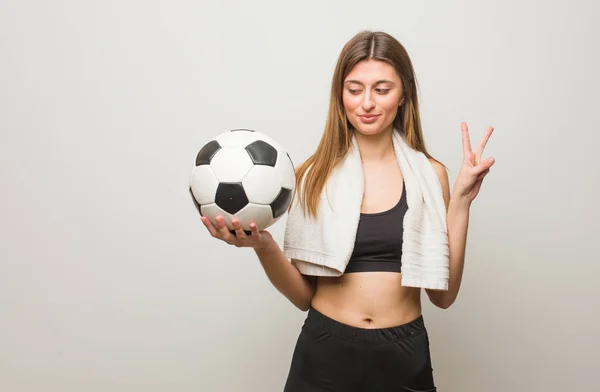 若いフィットネスロシアの女性の楽しさと幸せは勝利のジェスチャーをしています サッカーボールを持っている — ストック写真
