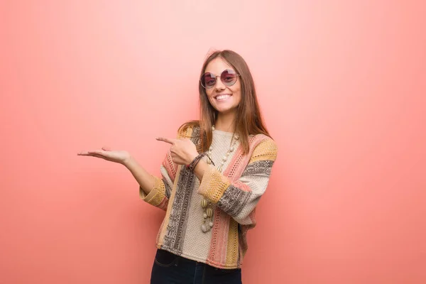 Joven Mujer Hippie Sobre Fondo Rosa Sosteniendo Algo Con Mano — Foto de Stock