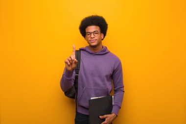 Genç Afrikalı Amerikalı öğrenci bir numarayı gösteriyor.