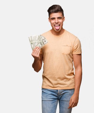 Dolar huni ve dostça gösteren dilini tutan genç adam
