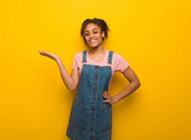 El ile bir şey tutan mavi gözlü genç Afro-Amerikan kız siyah