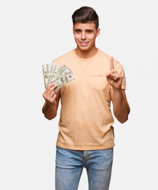 Genç adam bir numara gösterilen dolar tutan