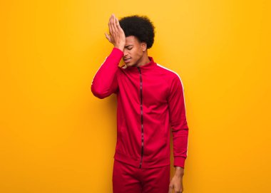 Turuncu bir duvarın üstünde genç bir zenci adam unutkan, bir şeyin farkına var.