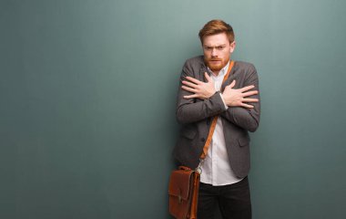 Genç kızıl saçlı iş adamı, düşük ateş yüzünden soğuyor.