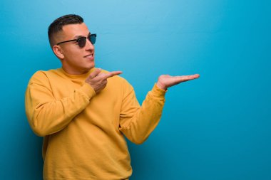 Genç Kolombiyalı bir adam elinde bir şey tutuyor.