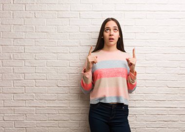 Genç modern kadın bir şey göstermek için yukarıyı şaşırttı