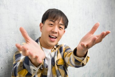 Genç Çinlinin yüzü çok mutlu. Ön tarafa sarılıyor.