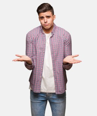 Genç serin şüphe ve omuzlarında shrugging adam