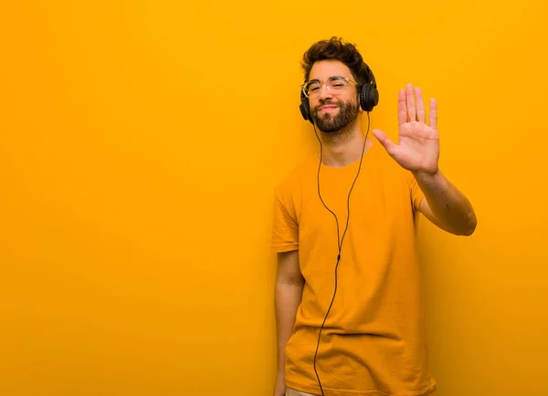 Ung Man Lyssnar Musik Sätta Hand Framför — Stockfoto