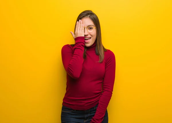 Young intellectual woman shouting happy and covering face with hand