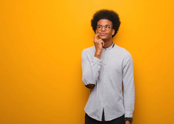 Jovem Afro Americano Sobre Uma Parede Laranja Duvidosa Confusa — Fotografia de Stock