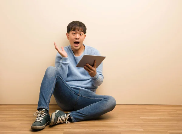 Joven Hombre Chino Sentado Usando Tableta Sorprendido Sorprendido —  Fotos de Stock