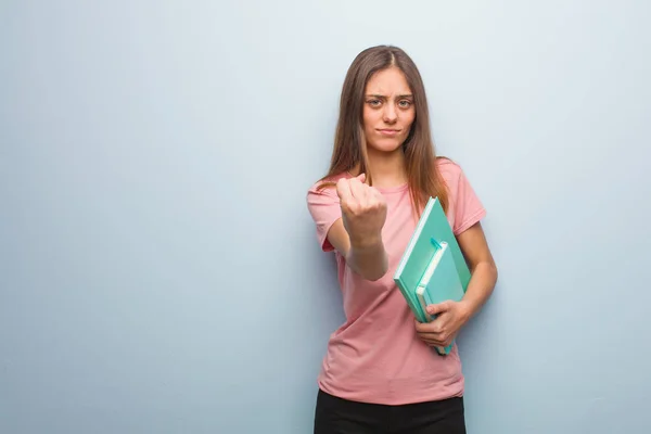 若いかなり白人女性の前に 怒りの表現に拳を示す 彼女は本を持っている — ストック写真