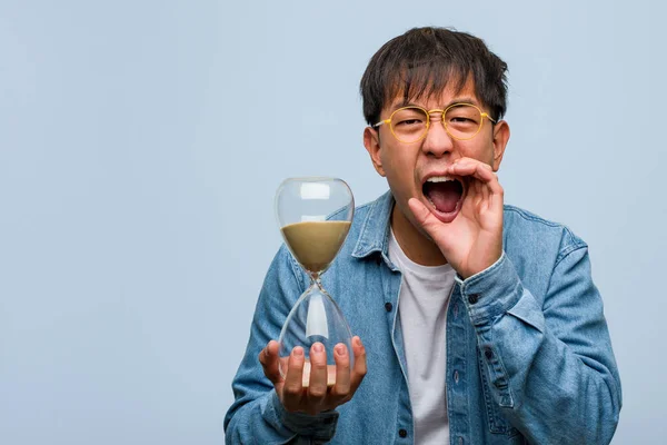 Joven Chino Sosteniendo Temporizador Arena Gritando Algo Feliz Frente — Foto de Stock