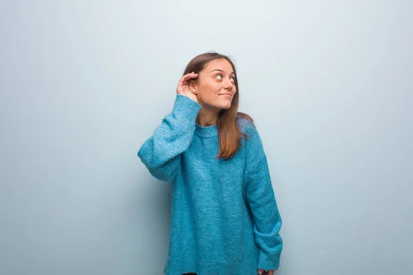 Jovem Mulher Bonita Vestindo Uma Camisola Azul Tentar Ouvir Uma — Fotografia de Stock