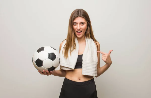 若いフィットネスロシアの女性は驚いた 成功し 繁栄を感じます サッカーボールを持っている — ストック写真