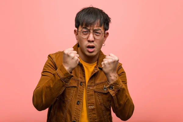 Young chinese man wearing a jacket angry and upset