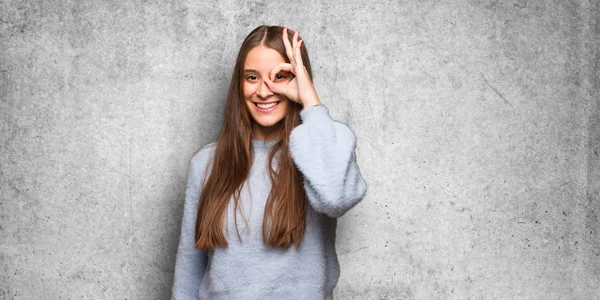 Young caucasian woman confident doing ok gesture on eye