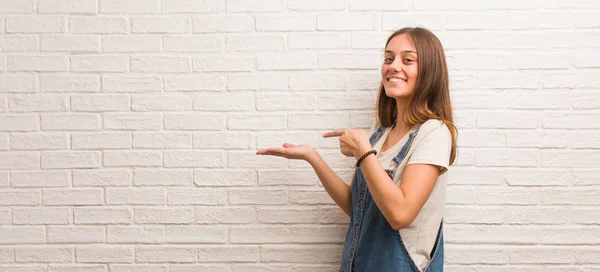 Young hipster woman holding something with hand