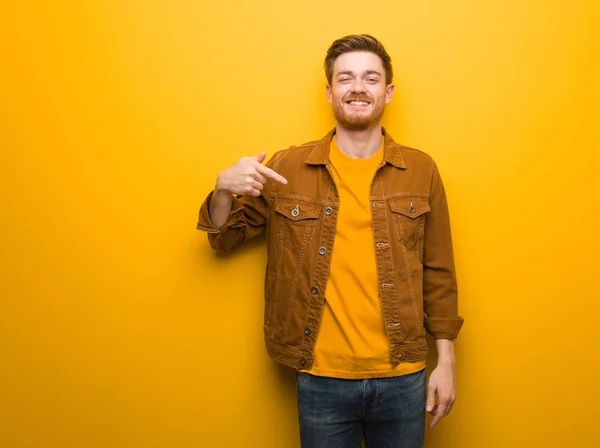 Jonge Roodharige Man Wijst Met Hand Naar Een Shirt Kopieerruimte — Stockfoto