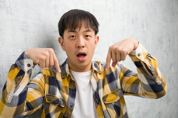 Ung Kinesisk Man Ansikte Närbild Pekar Botten Med Fingrar — Stockfoto
