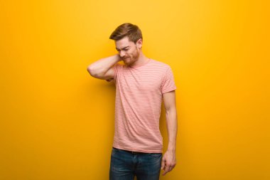 Kızıl saçlı genç adam boyun ağrısı çekiyor.