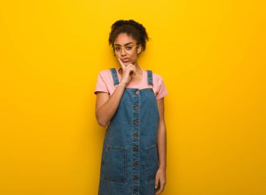 Mavi gözlü genç siyah afro-amerikan kız şüphe ve karışık