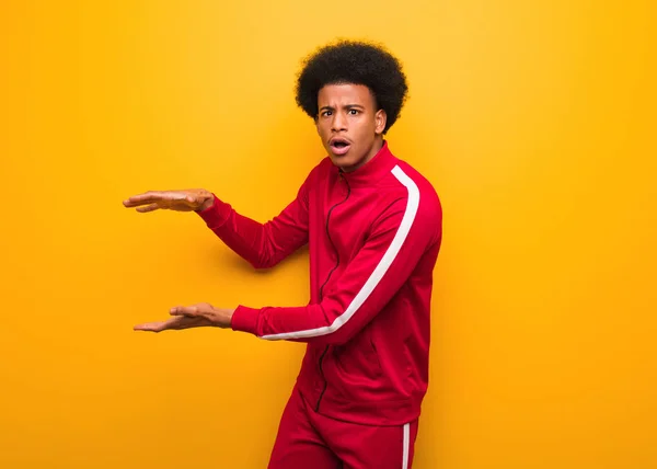 Joven Hombre Negro Deporte Sobre Una Pared Naranja Sosteniendo Algo — Foto de Stock