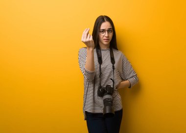 Genç fotoğrafçı kadın tipik bir İtalyan hareketi yapıyor.