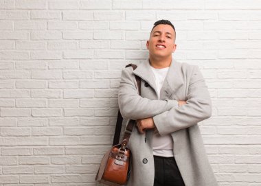 Gülümseyen ve rahat genç latin iş adamı geçiş kollar,