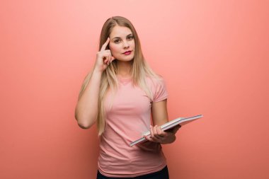 Genç, güzel Rus kız bir fikir düşünüyor. Elinde kitaplar var..