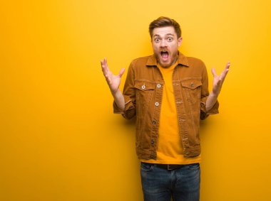 Genç kızıl saçlı adam bir zafer ya da başarı kutluyor