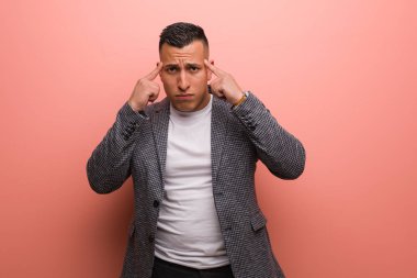 Genç, zarif Latin adam konsantrasyon jesti yapıyor.